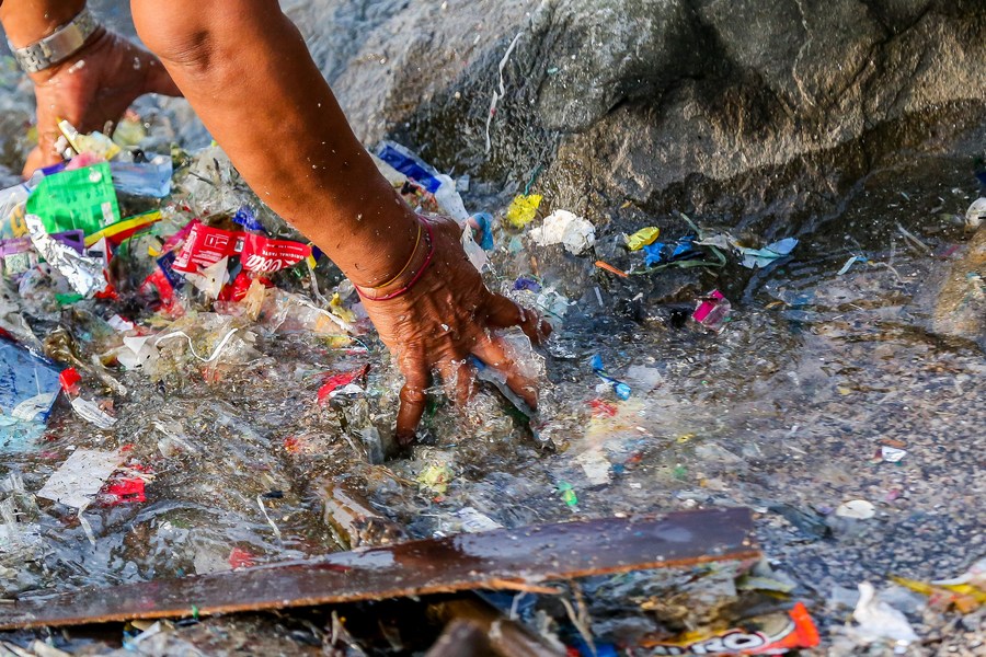 A volunteer collects rubbish during an activity to mark the International Coastal Cleanup Day along the coast of Manila Bay in Manila, the Philippines, September 16, 2023. /Xinhua