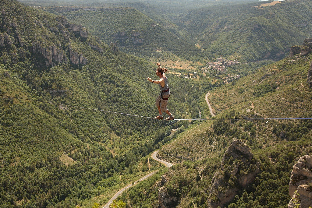 A man walks across a highline rigged between two cliffs at the Gorges de la Jonte in Cevennes National Park in Millau, France. /CFP