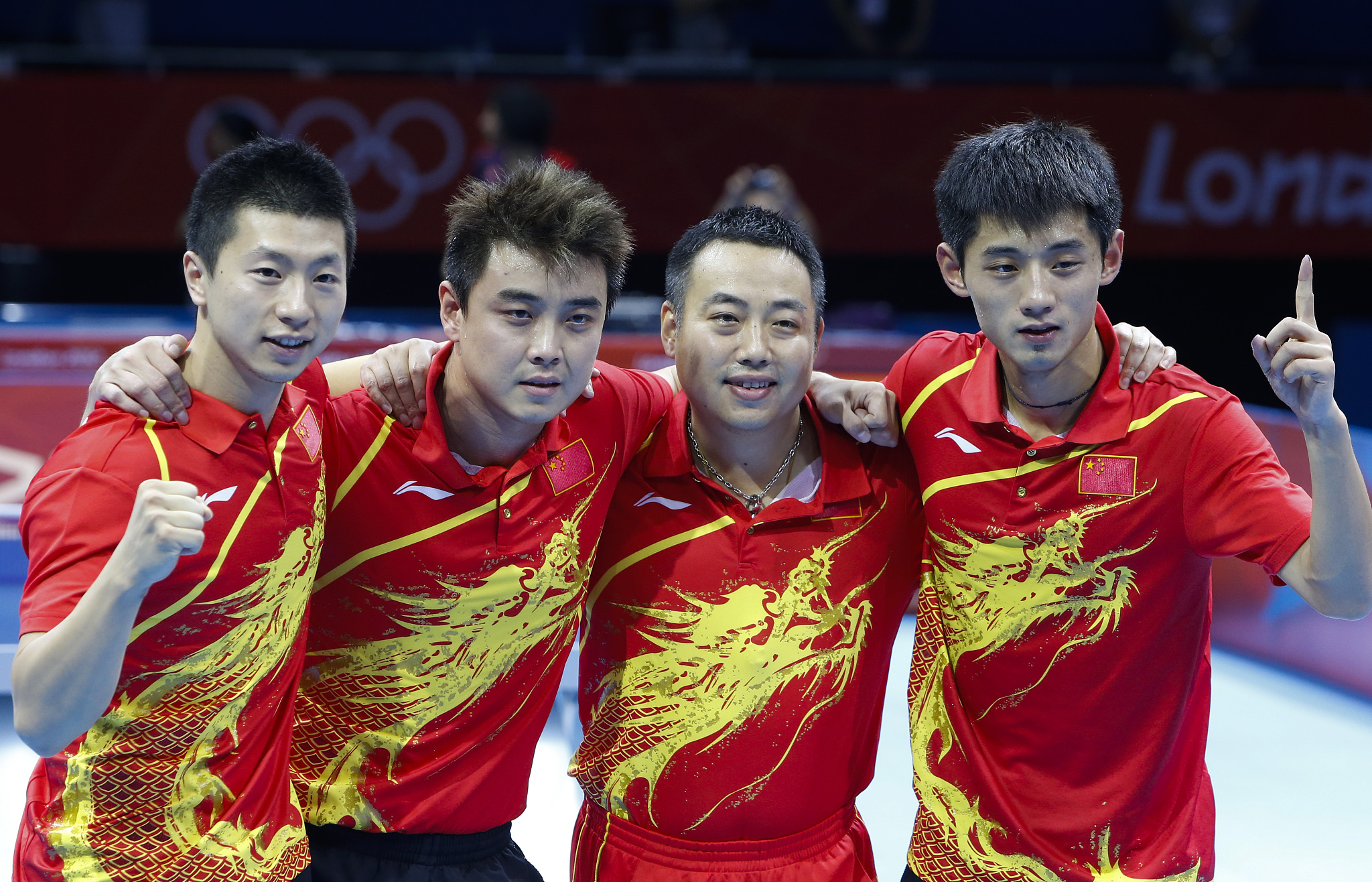 L-R: Ma Long, Wang Hao, coach Liu Guoliang, and Zhang Jike celebrate after winning the gold medal in the table tennis men's team final during the London 2012 Olympic Games in London, England, August 8, 2012. /CFP