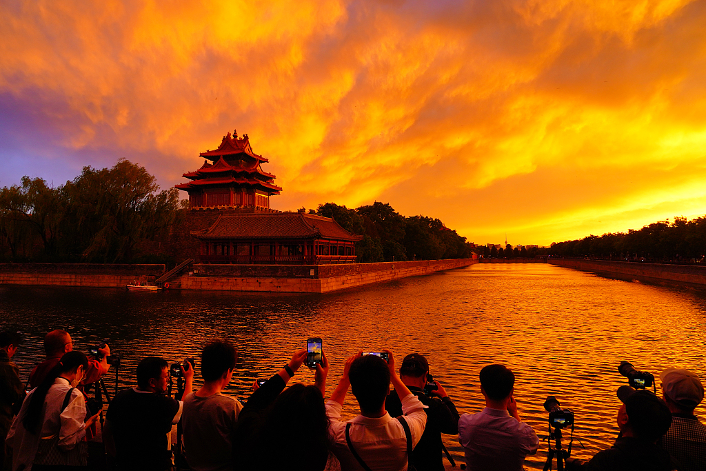 Onlookers snap pictures of a burning red sky at the Forbidden City in Beijing, May 14, 2024. /CFP
