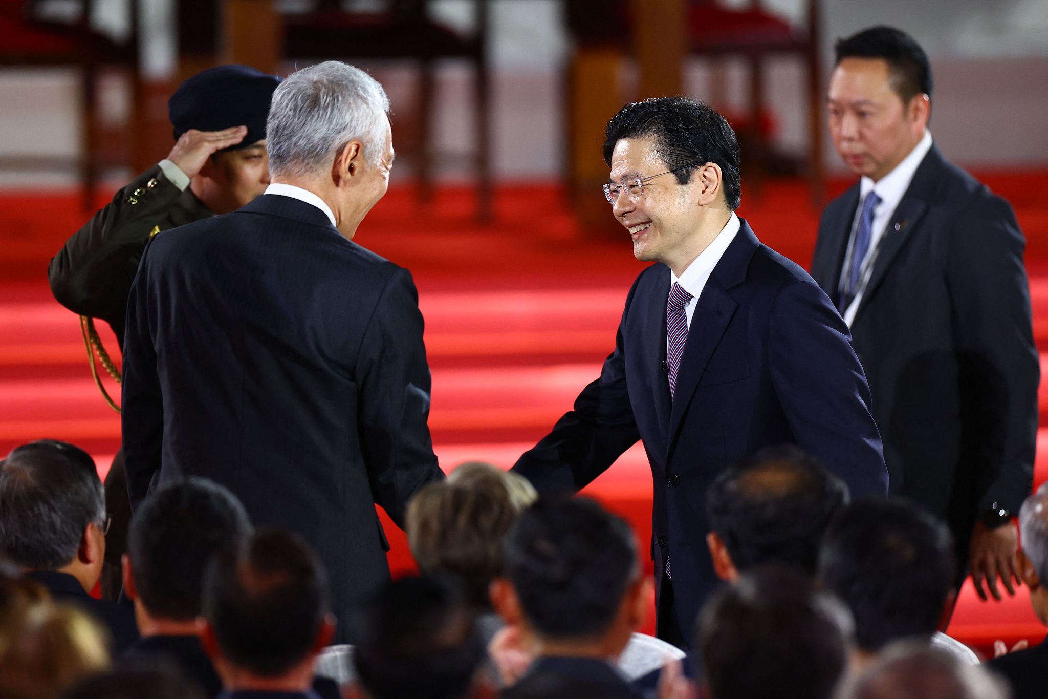 Singapore's incoming Prime Minister Lawrence Wong (2nd R) shakes hands with outgoing prime minister Lee Hsien Loong (2nd L) during the swearing-in ceremony at the Istana in Singapore, May 15, 2024. /CFP