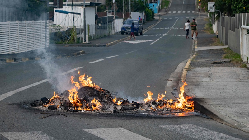A fire in the street after a supermarket was looted and shops vandalized in the N'Gea district of Noumea, May 14, 2024. /CFP
