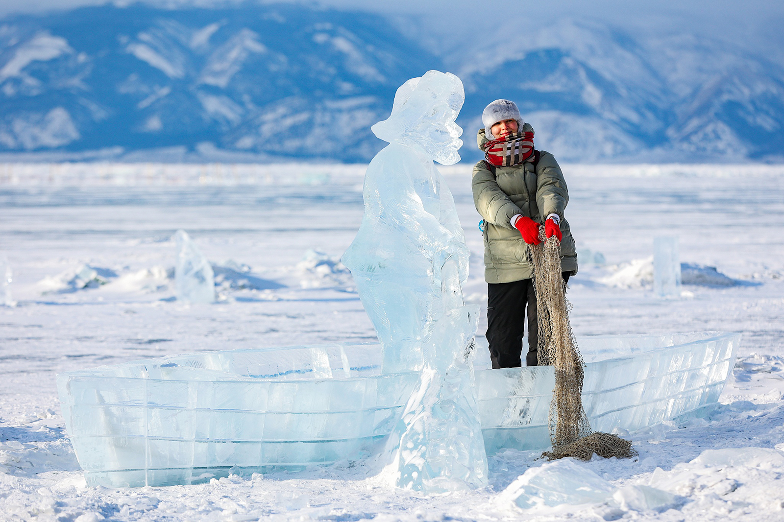 A visitor poses for photos with an ice sculpture during the Olkhon Ice Fest on the shores of Lake Baikal's Olkhon Island in Russia on February 17, 2024. /CFP