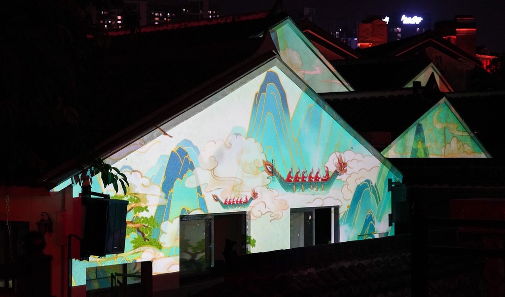 Murals of dragon boats are projected onto the walls at Guanlan Ancient Market in Shenzhen, Guangdong Province, May 15, 2024. /IC