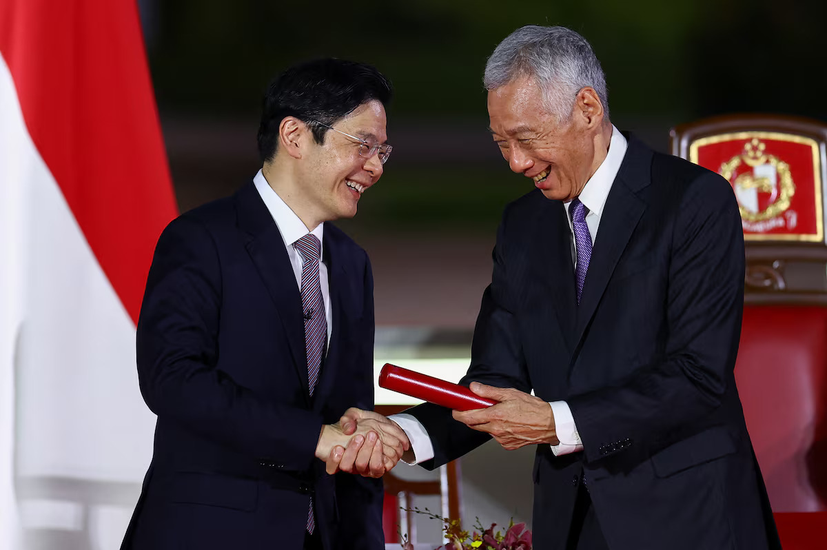 Singapore's new Prime Minister Lawrence Wong shakes hands with Senior Minister (and outgoing prime minister) Lee Hsien Loong as Wong is sworn in as Singapore's fourth prime minister at the Istana, in Singapore, May 15, 2024. /Reuters