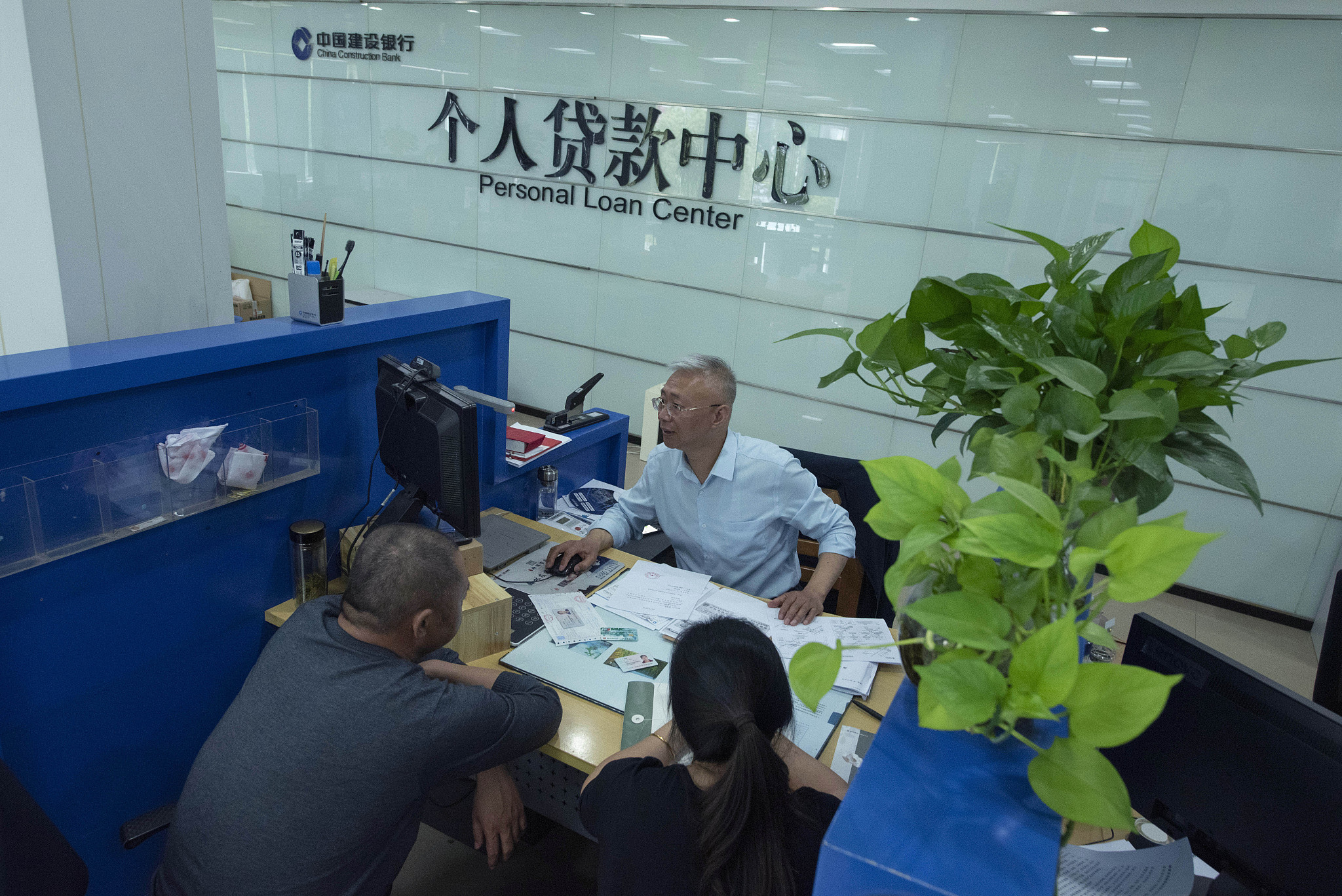A bank clerk in Nantong, Jiangsu Province is handling individual residential housing loan business for customers on May 17. /CFP