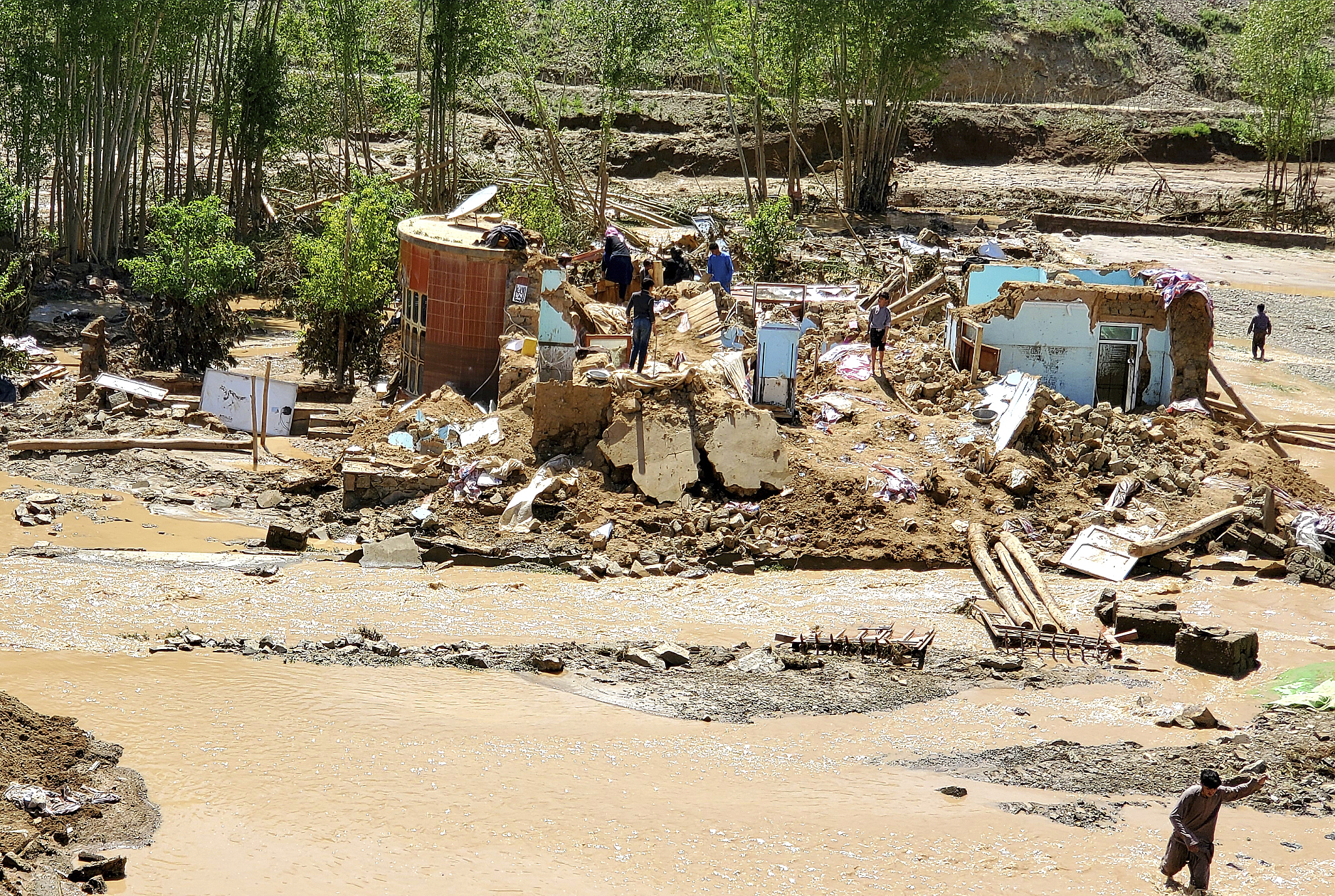 Afghan men collect their belongings from damaged homes after heavy flooding, Ghor Province, Afghanistan, May 18, 2024. /CFP