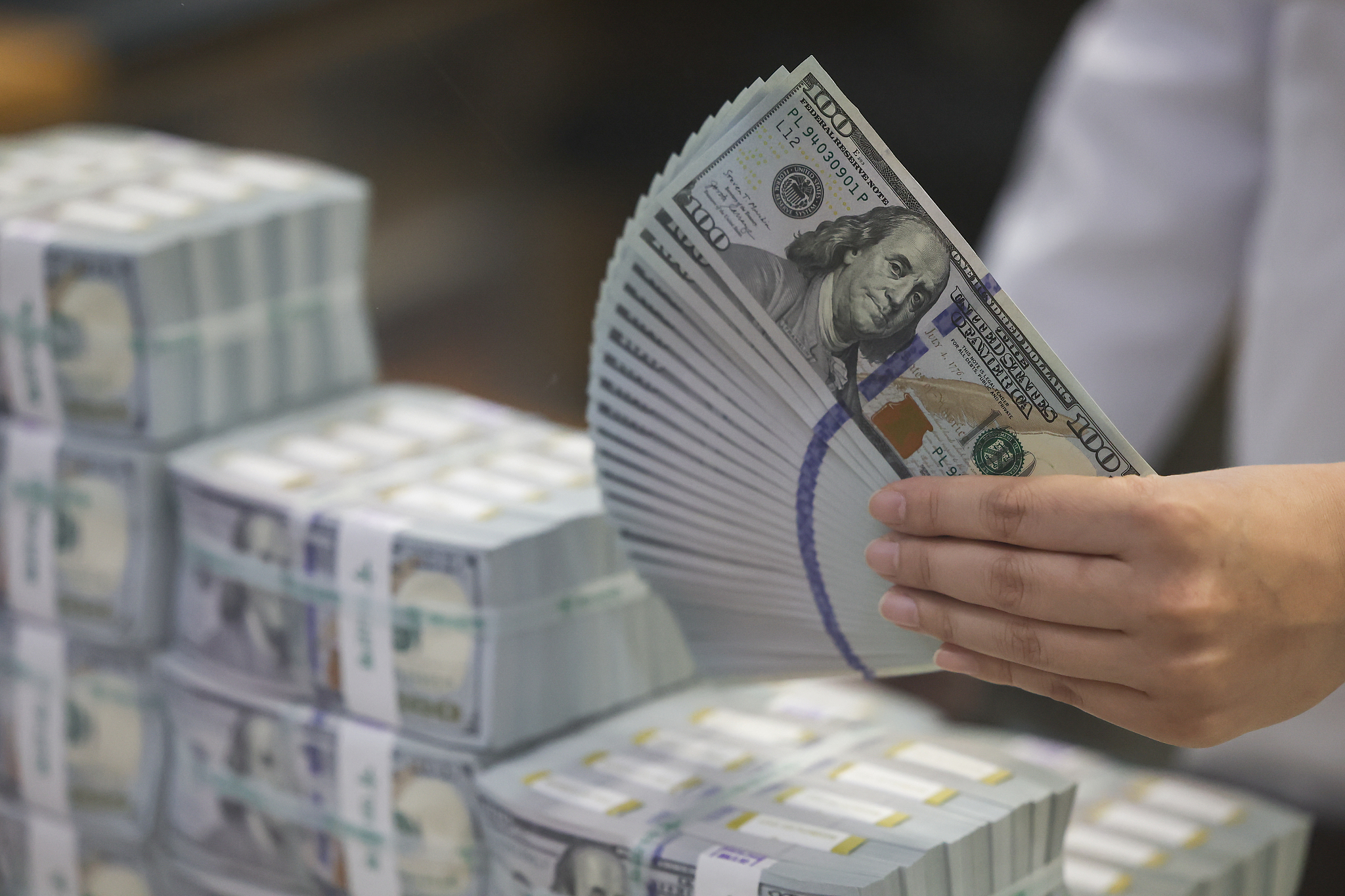 A staff of Hana Bank displays dollars in Seoul, South Korea, May 7, 2024. /CFP