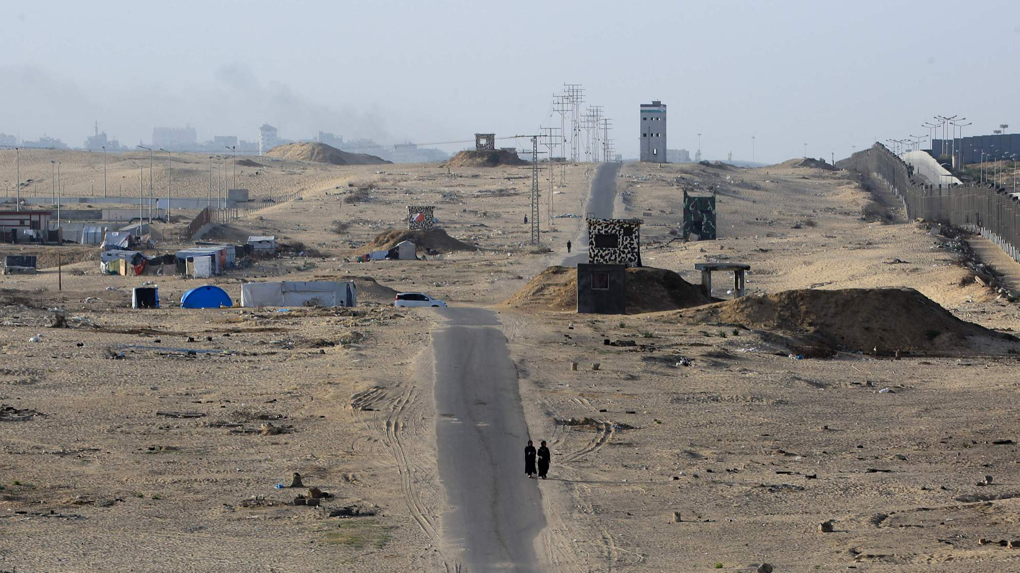 Two women walk on an asphalted road in the middle of a deserted camp for displaced Palestinians on the border with Egypt in Rafah in the southern Gaza Strip on May 22, 2024, amid the ongoing conflict between Israel and the Palestinian Hamas group. /CFP