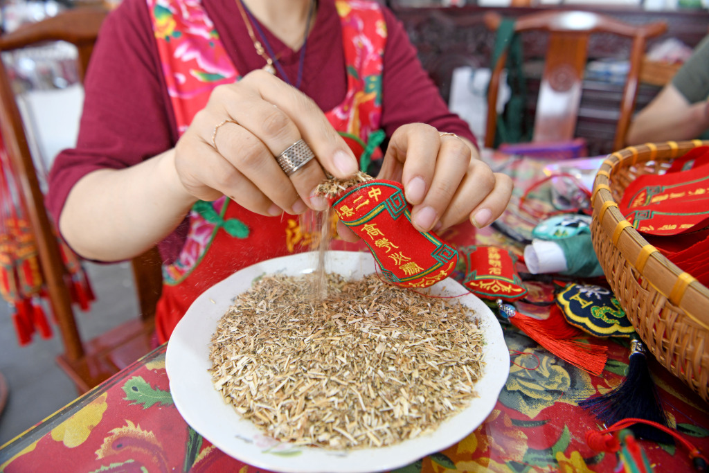 Embroidered sachets are filled with herbs in Shouxian County of Huainan, Anhui Province on May 21, 2024. /CFP