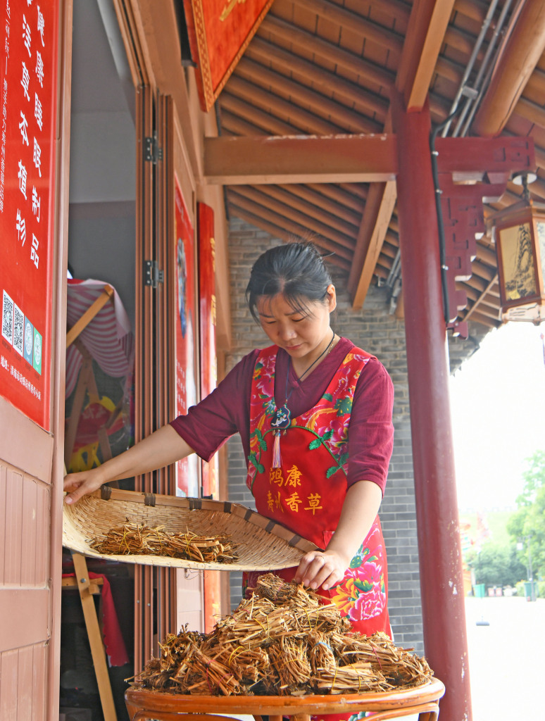 A women sorts through herbs in Shouxian County of Huainan, Anhui Province on May 21, 2024. /CFP