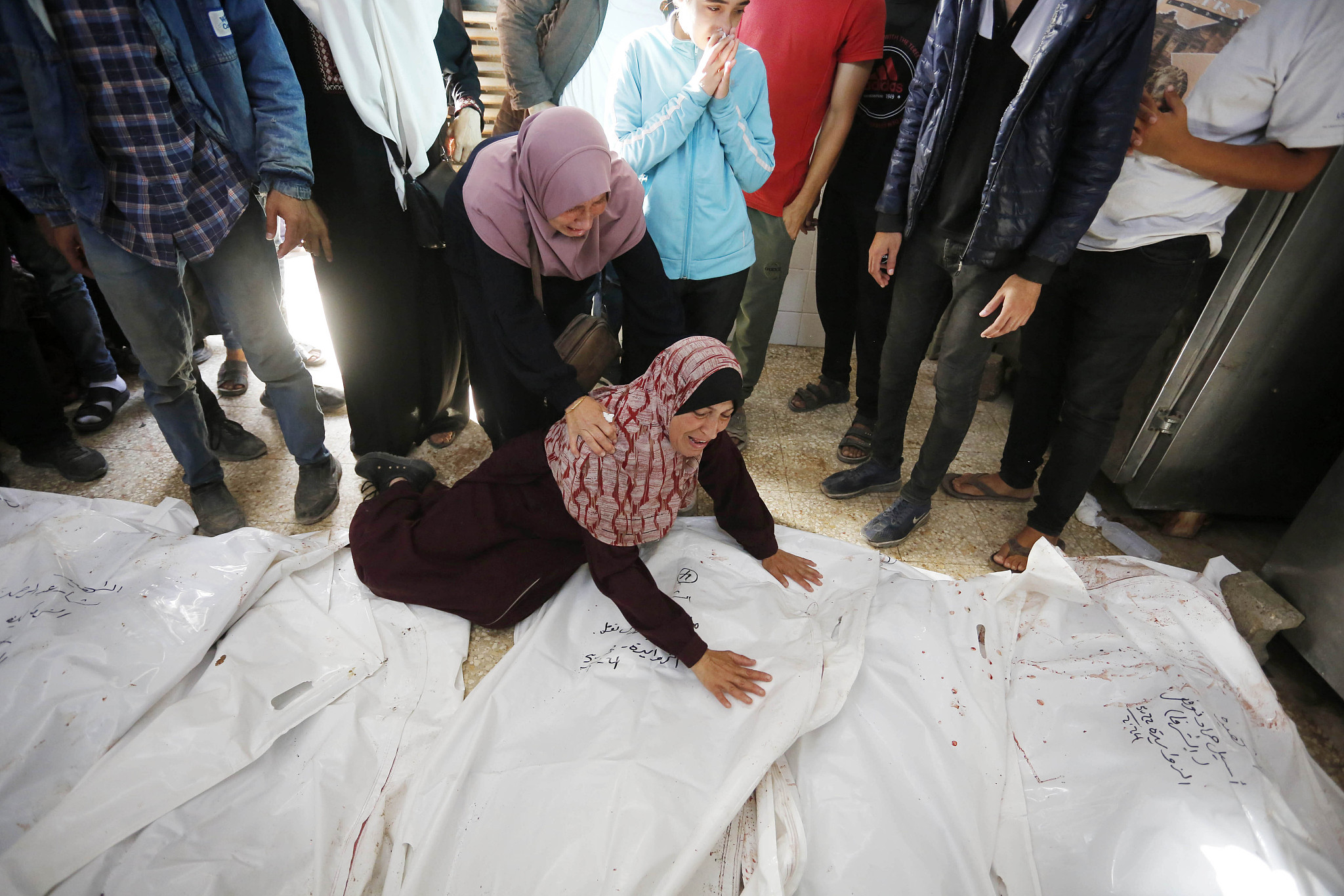 Relatives of Palestinians who lost their lives in Israeli attacks mourn as the bodies are brought to a morgue at Al-Aqsa Hospital in Deir el-Balah, Gaza, May 22, 2024. /CFP