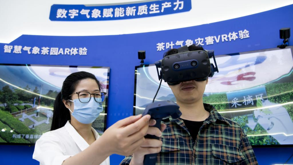 A visitor (R) tries digital VR devices at the on-site experience area for the 7th Digital China Summit in Fuzhou City, southeast China's Fujian Province, May 23, 2024. /Xinhua