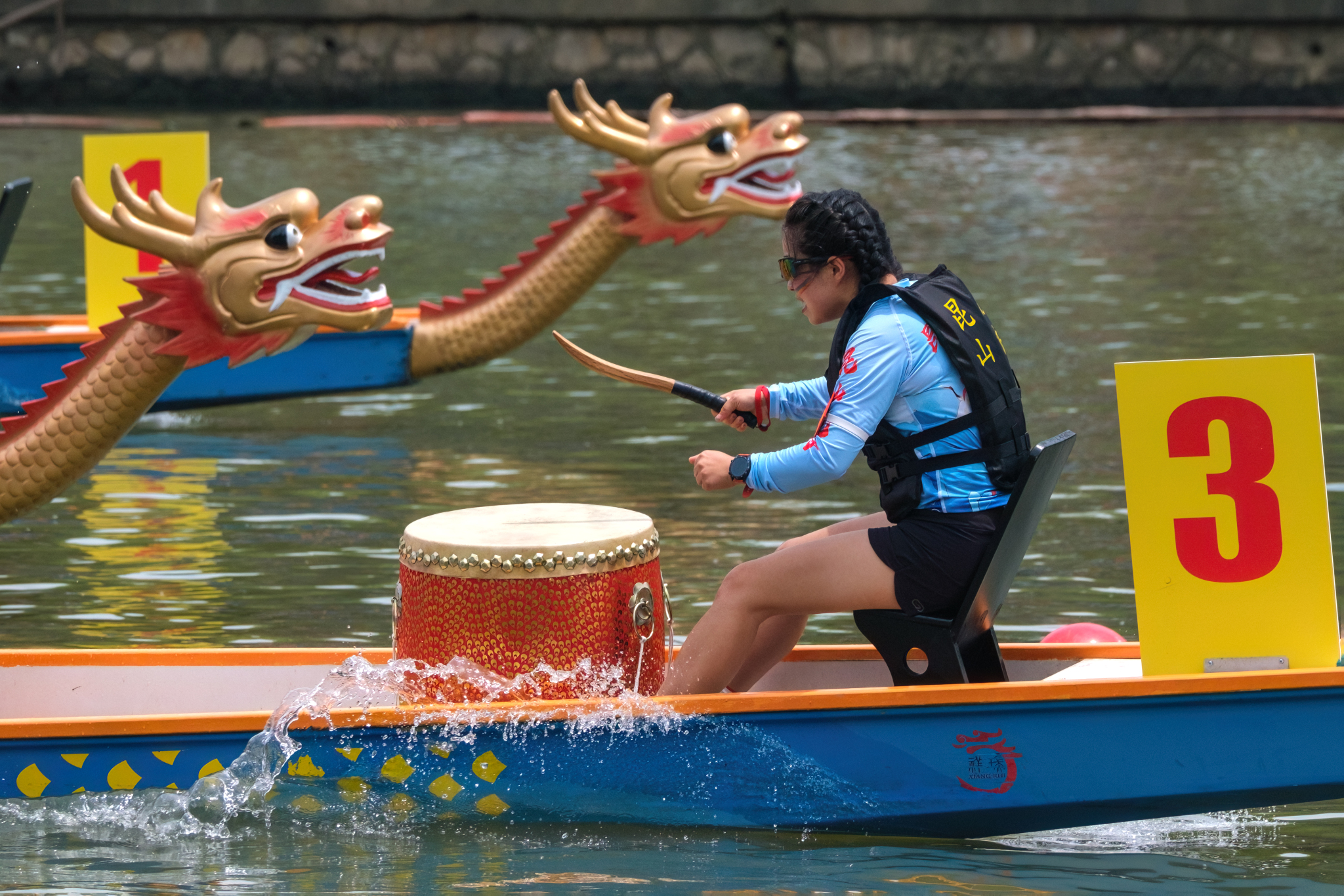 A woman beats her team's drum during a dragon boat race held on the Qinhuai River in Nanjing, Jiangsu Province on May 19, 2024. /CFP