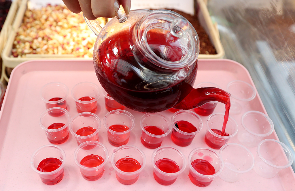 Rose tea is poured into small cups at the Shuangqiao night market in Kunming, Yunnan Province on May 23, 2024. /CFP