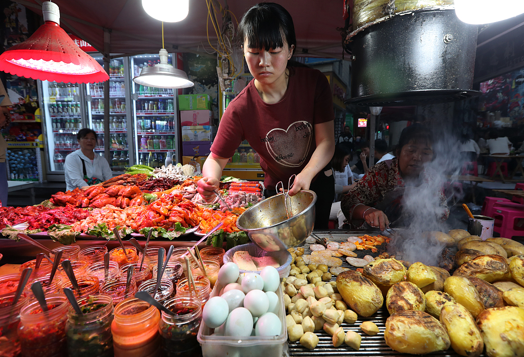 A variety of Kunming-style barbecue dips are provided at a food stall in the Shuangqiao night market in Kunming, Yunnan Province on May 23, 2024. /CFP