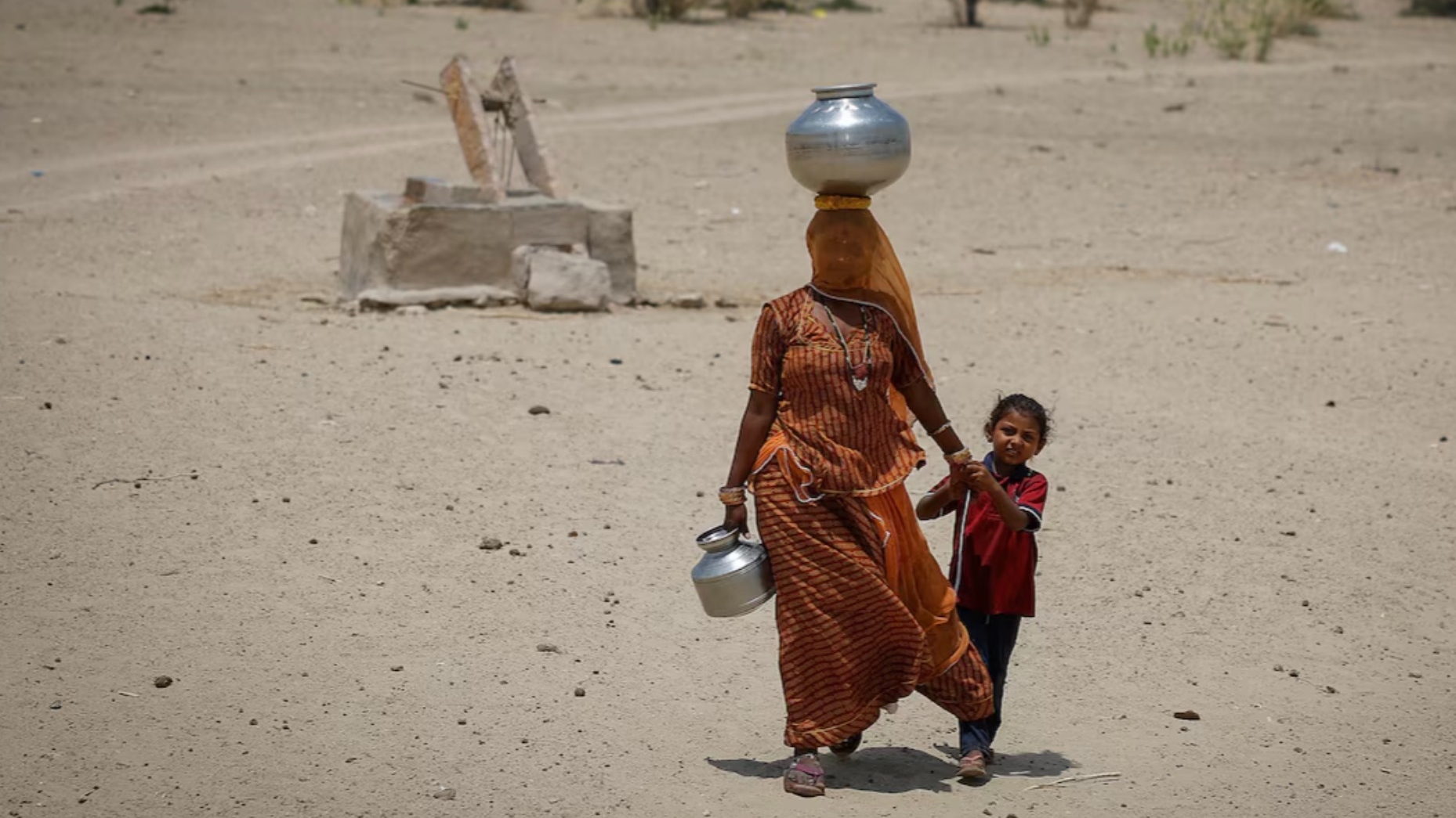 A woman walks back towards her home after filling water from a shallow well in a desert area on a hot summer day in Barmer, Rajasthan, India, April 26, 2024. /Reuters