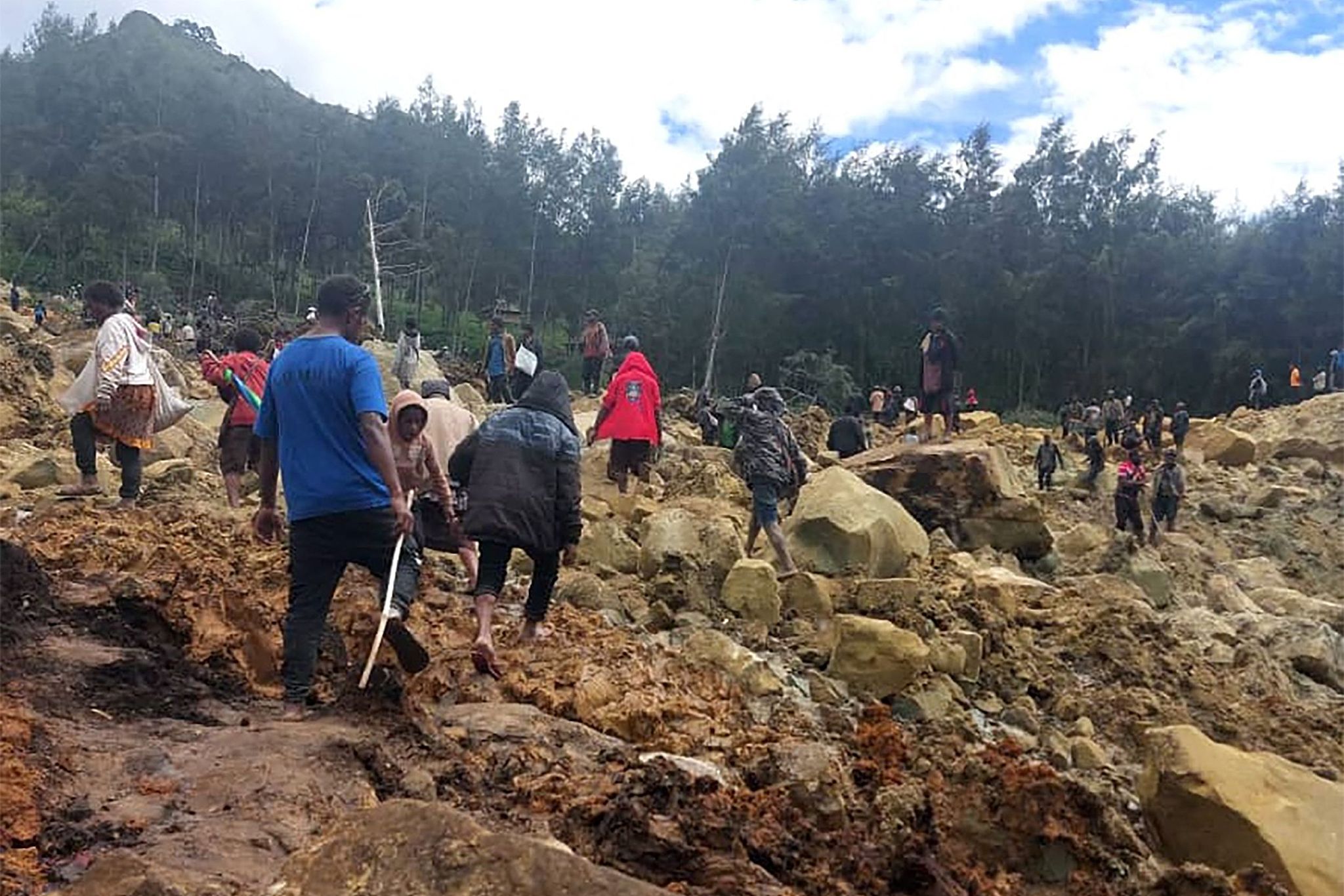 Locals gather at the site of a landslide, Maip Mulitaka region, Enga Province, Papua New Guinea, May 25, 2024. /International Organization for Migration (IOM)/Benjamin Sipa