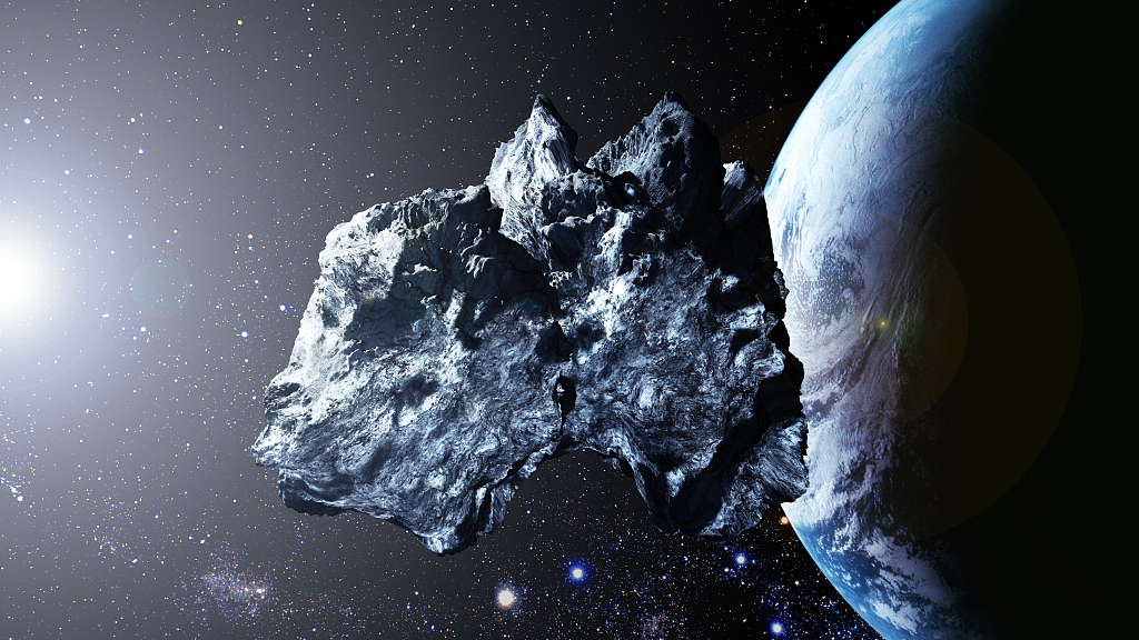 An illustration shows a near-Earth asteroid and Earth. /CFP