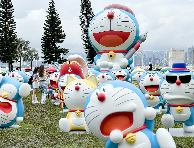 Visitors take photos with models of the Japanese animated character Doraemon at the Sun Yat Sen Memorial Park in Hong Kong, May 25, 2024. /CFP