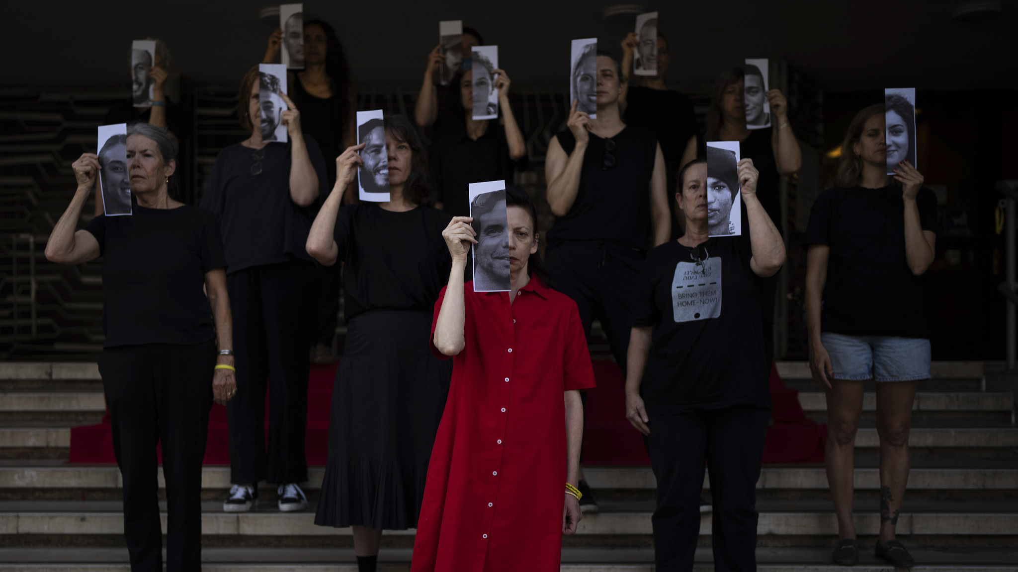 Relatives and supporters of Israeli hostages held by Hamas in Gaza hold photos of their loved ones during a performance calling for their return in Tel Aviv, Israel, May 23, 2024. /CFP