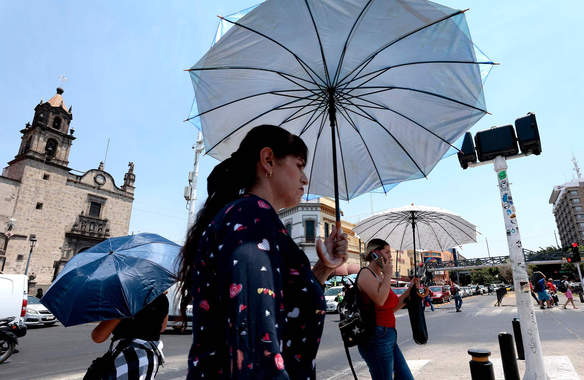 People protect themselves from the sun with umbrellas during a heat wave hitting the country in Jalisco State, Mexico, on May 23, 2024. /CFP