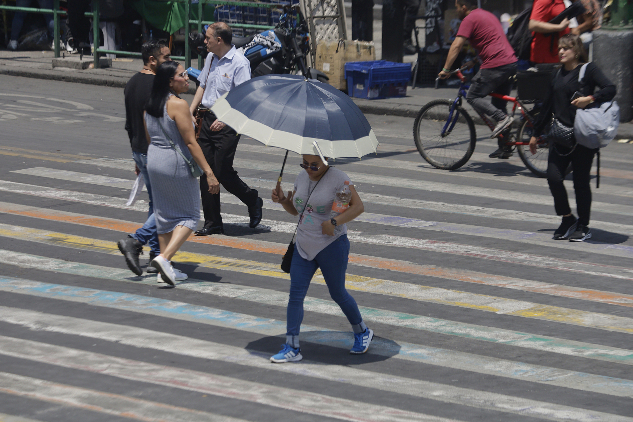 A person is covering herself from the sun with an umbrella in the streets of Mexico City's Zocalo, May 24, 2024. /CFP