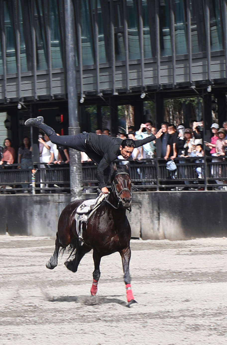 A rider performs a stunt on horseback at a horse base in Urumqi, Xinjiang. /CGTN