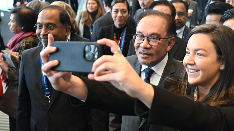 Malaysian Prime Minister Anwar Ibrahim (2R) takes a selfie following the 