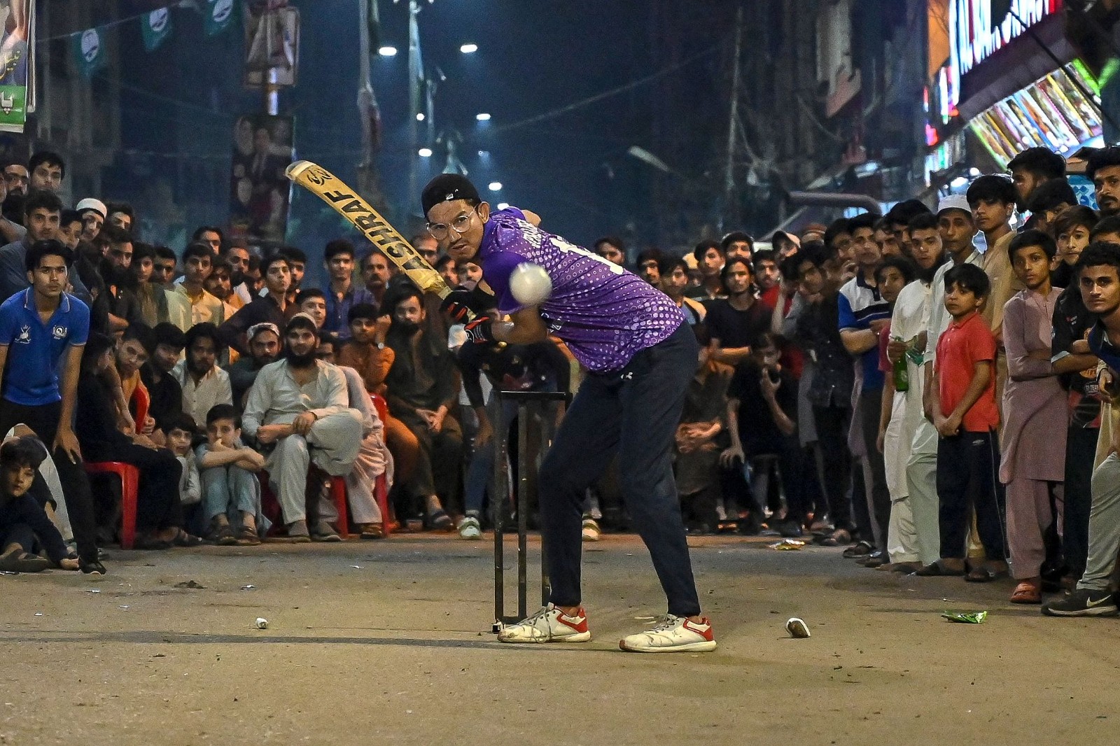 A youngster bats at a tape ball night cricket match as spectators watch during the Islamic holy month of Ramadan in Karachi, Pakistan, on March 27, 2024. Cricket enjoys immense popularity in South Asia. /CFP