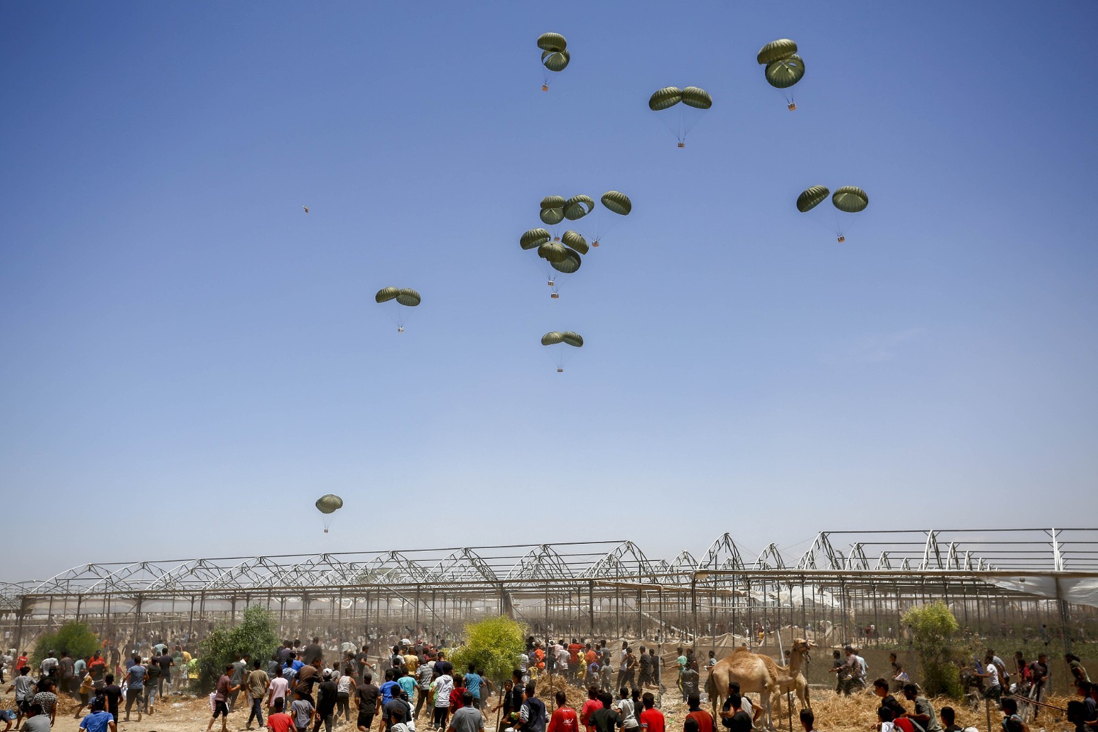 Humanitarian aid packages land with the help of parachutes after being dropped from a plane as Israeli attacks continue over Gaza in Al Mawasi district of Khan Yunis, Gaza, May 30, 2024. /CFP