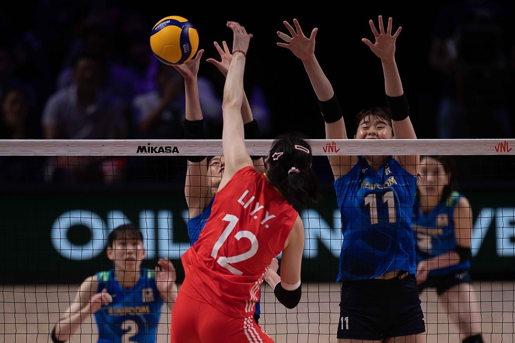 Japanese players block a shot from Li Yingying of China (in red) during their FIVB VNL match in south China's Macao Special Administrative Region, May 31, 2024. /CFP