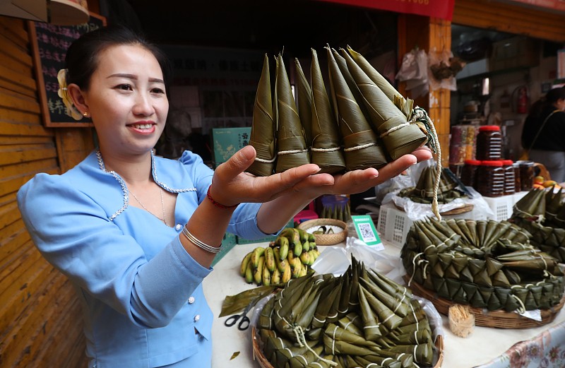 A vendor demonstrates zongzi, a traditional food of the Dragon Boat Festival, at a market in Kunming City, Yunnan Province, June 1, 2024. /CFP
