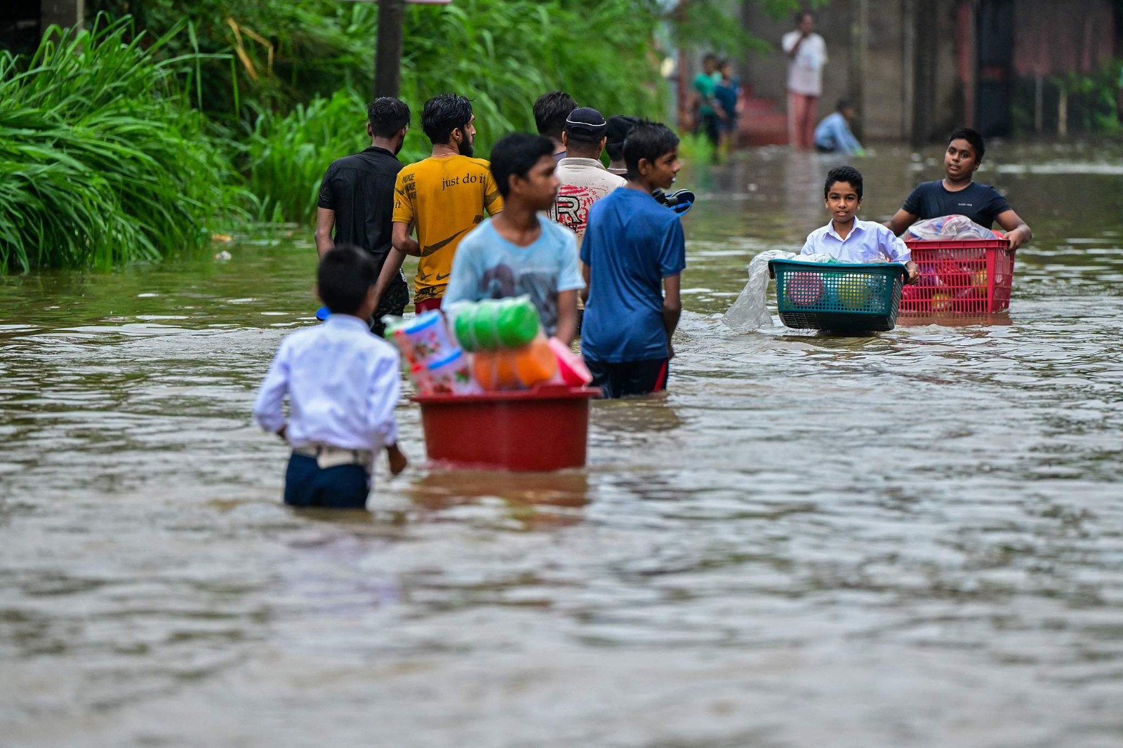 Residents wade through a flooded street after heavy rains in Malwana on the outskirts of Colombo, Sri Lanka, June 2, 2024. /CFP