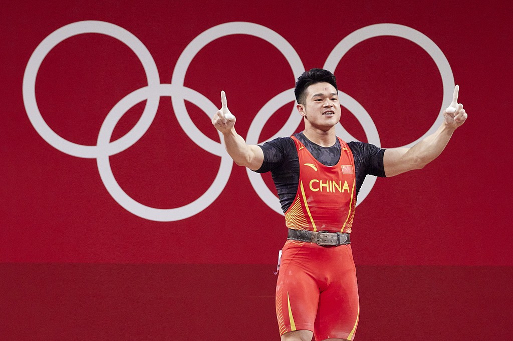 Shi Zhiyong of China celebrates after winning the gold medal in men's weightlifting 73-kilogram event in the Tokyo Olympics at Tokyo International Forum in Tokyo, Japan, July 28, 2021. /CFP