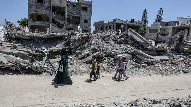 People walk by destroyed buildings after an Israeli air strike in the city of Deir al-Balah, Gaza, June 2, 2024. /CFP
