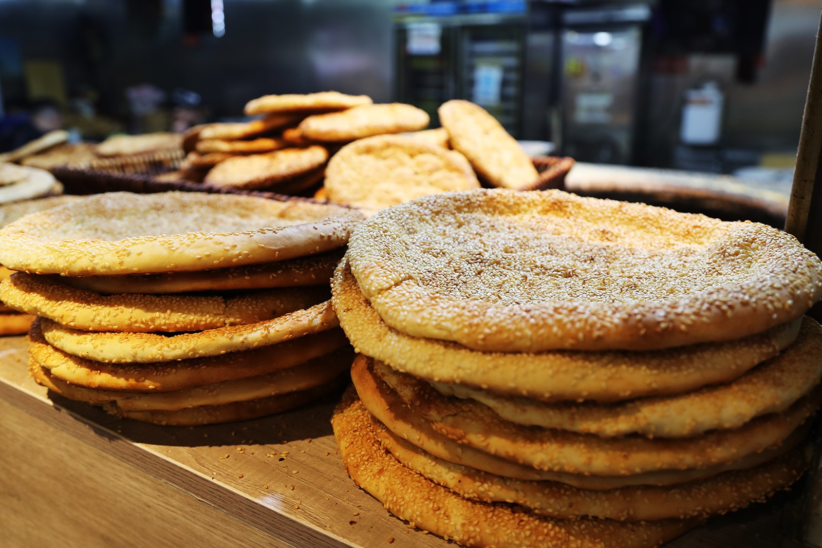 Piles of nang, a kind of staple roasted flatbread from Xinjiang, are displayed for sale in a store at the Xinjiang International Grand Bazaar in Urumqi. /CGTN