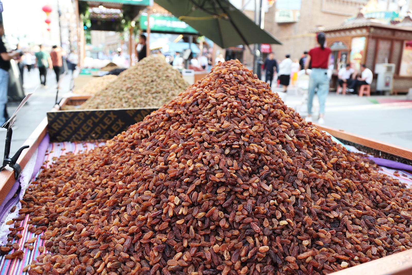 Mounds of raisins are displayed for sale at the Xinjiang International Grand Bazaar in Urumqi. /CGTN