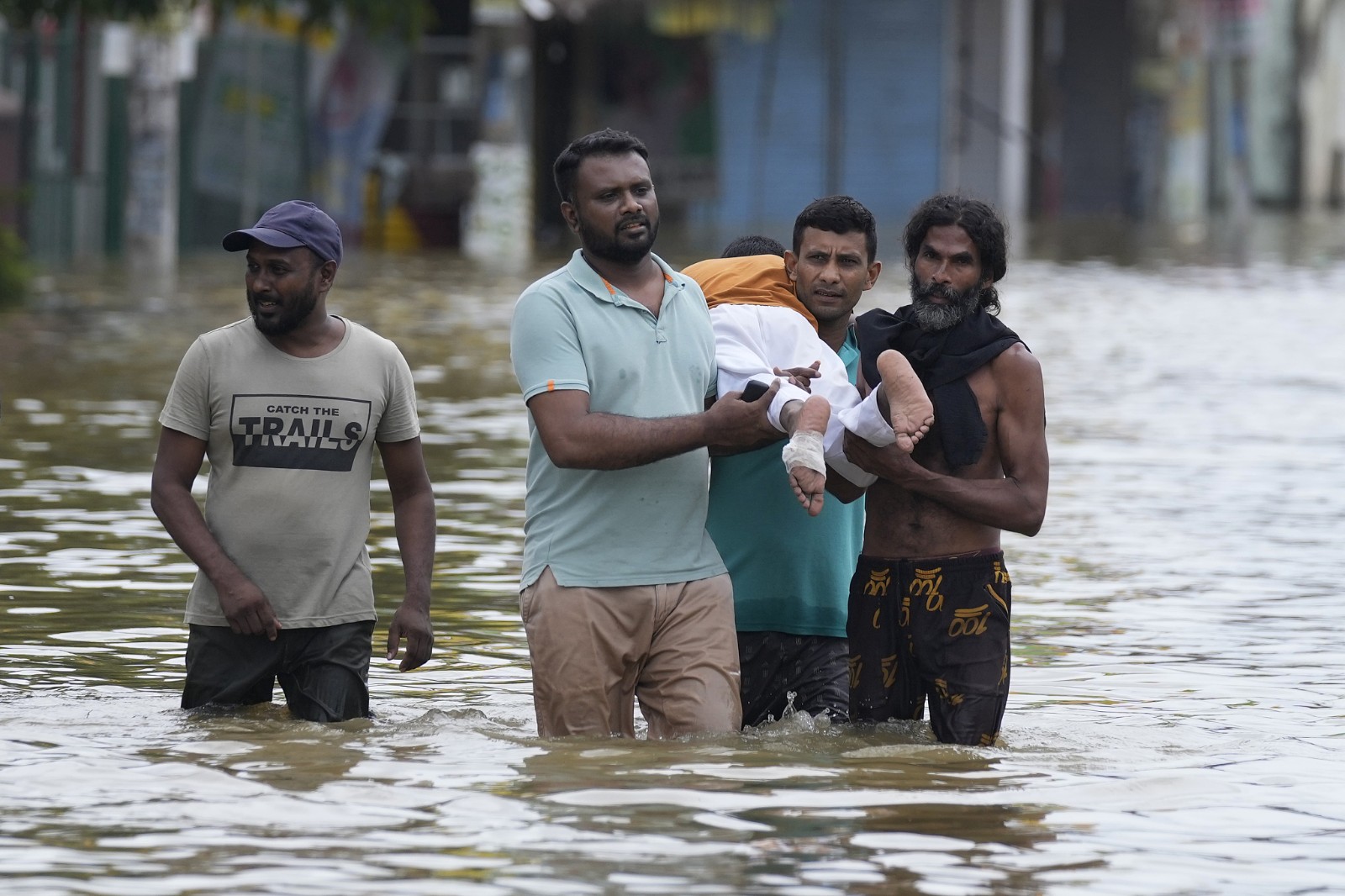 People carry an injured boy as they wade through a flooded street in Biyagama, a suburb of Colombo, Sri Lanka, June 3, 2024. /CFP