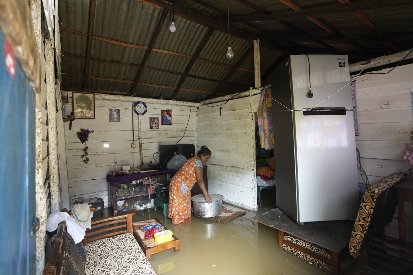 A woman removes utensils from her house, which is submerged with floodwaters, in Kelaniya, a suburb of Colombo, Sri Lanka, June 3, 2024. /CFP