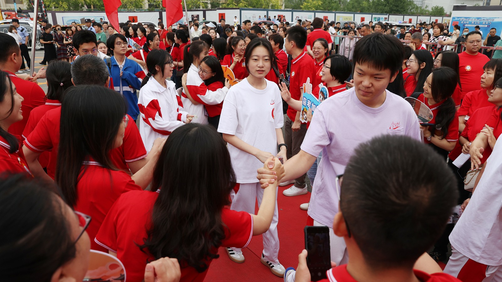Candidates shake hands with family members and teachers before entering an examination site in Beijing, China, June 7, 2024. /CFP