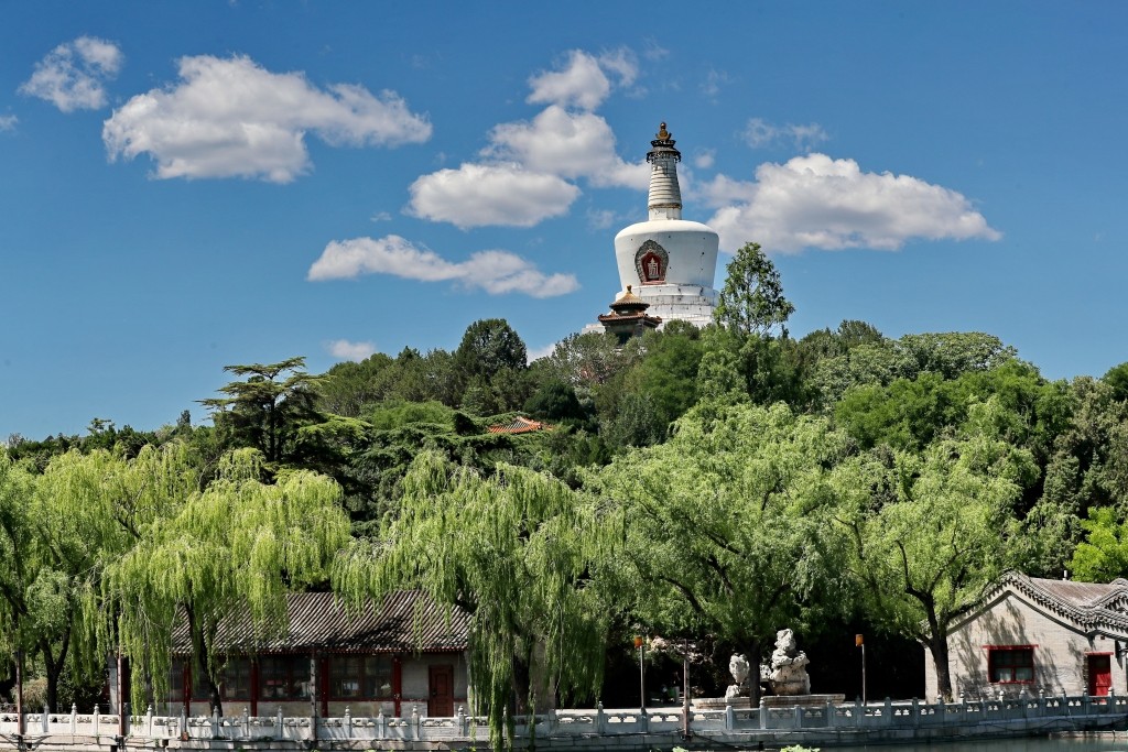 The White Pagoda is seen in Beihai Park in Beijing, standing on top of a green hill against a backdrop of a blue sky and white clouds on May 31, 2024. /CFP