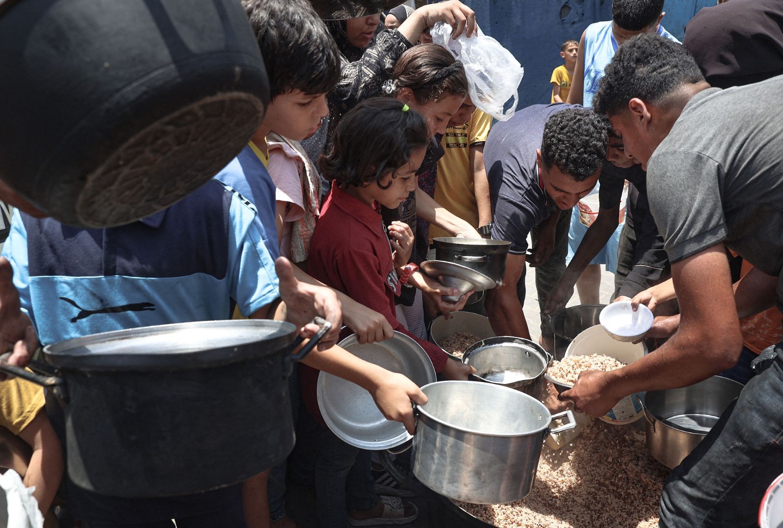 Palestinians queue for meal rations at a communal food distribution point in al-Bureij refugee camp in the besieged Gaza, June 3, 2024. /CFP