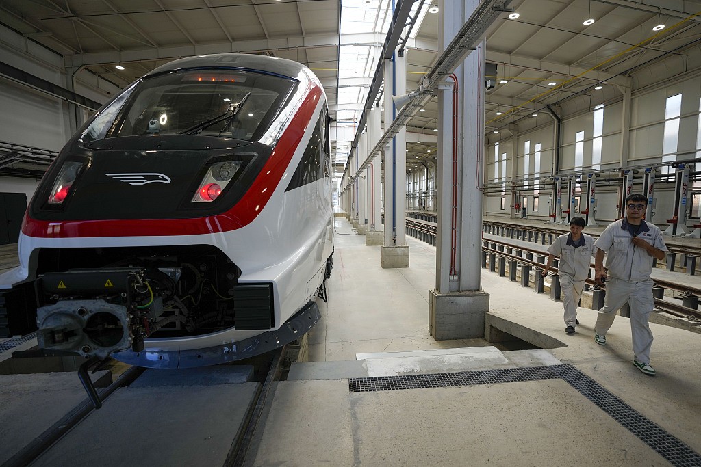 Chinese workers walk by a new electric high-speed train for the Belgrade-Budapest railway at the Zemun station, Belgrade, Serbia, June 7, 2024. /CFP