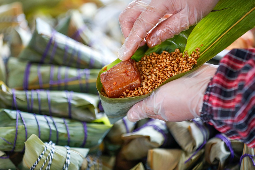 A villager makes zongzi with stinky mandarin fish, a popular traditional local dish in Huangshan, Anhui Province. /VCG