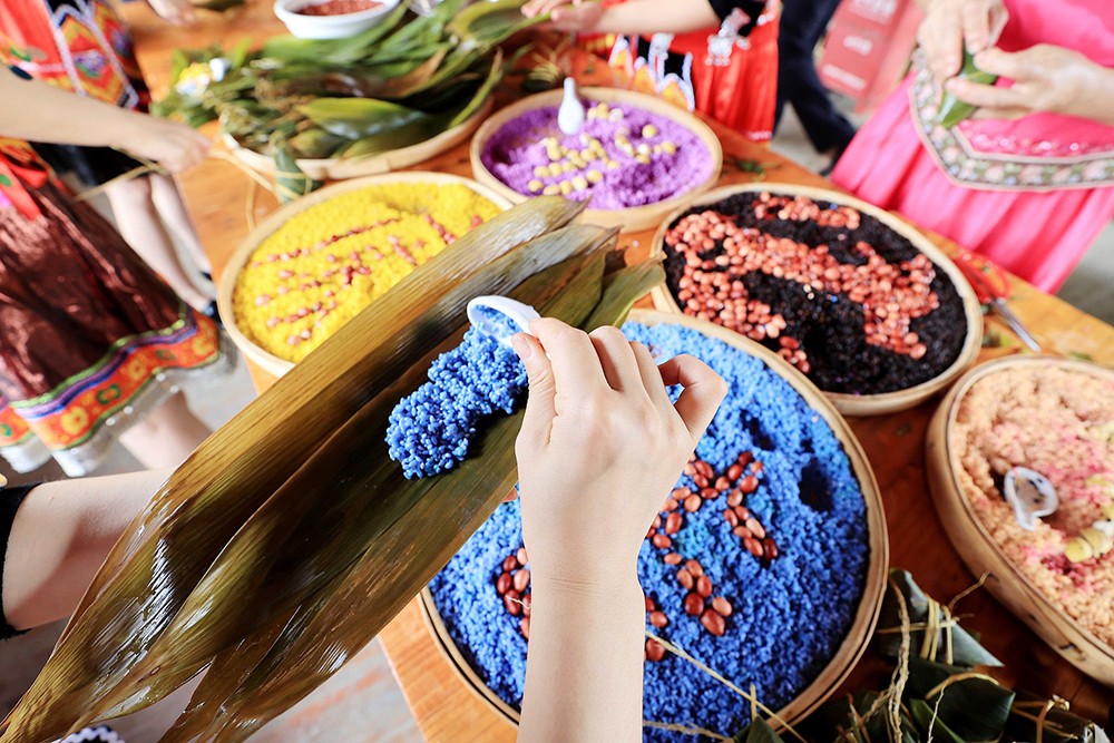 Villagers make zongzi with colorful rice in Liuzhou, Guangxi Zhuang Autonomous Region. /VCG