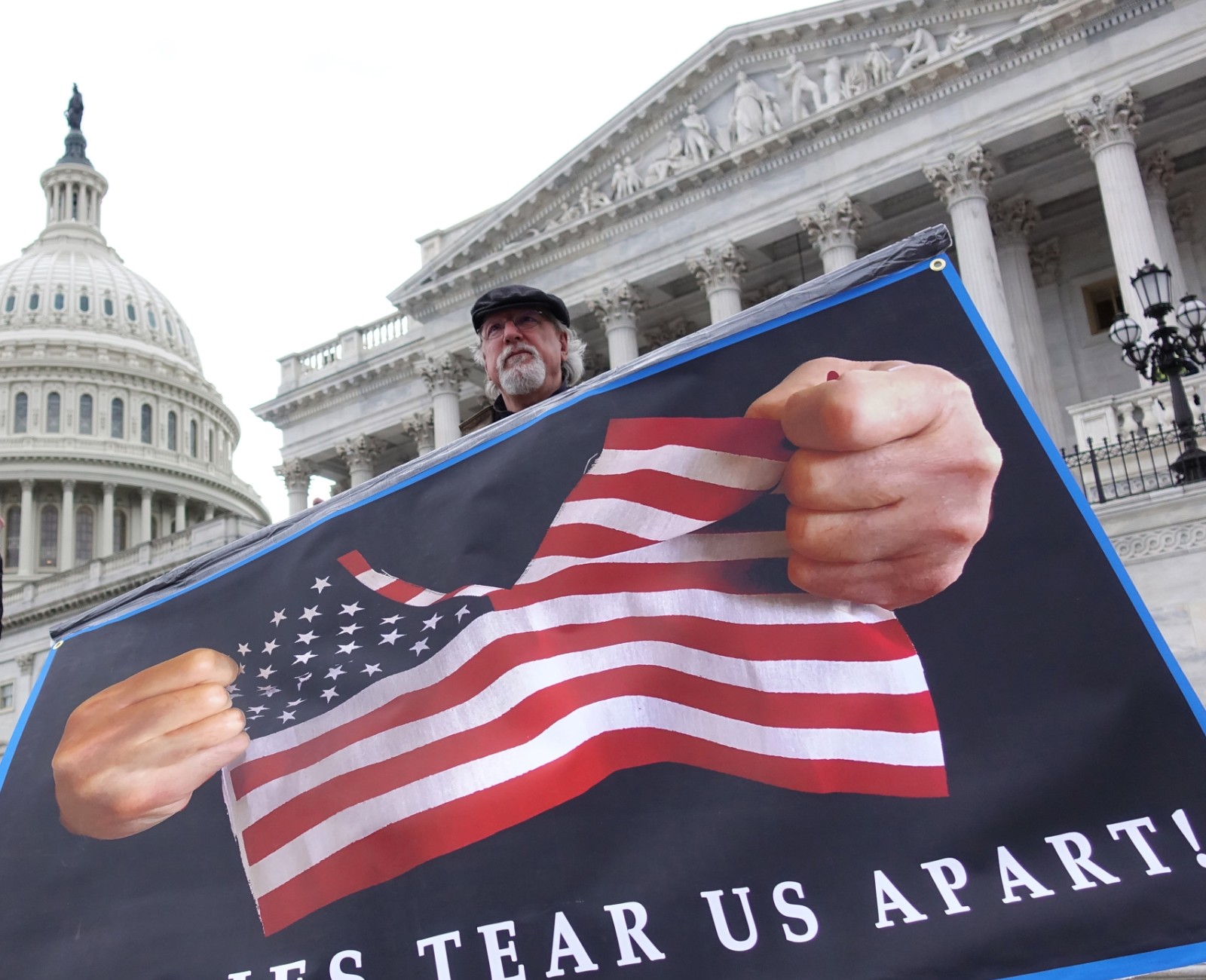 File photo shows A protester holding a poster stands in front of the Capitol in Washington D.C., the United States. /Xinhua
