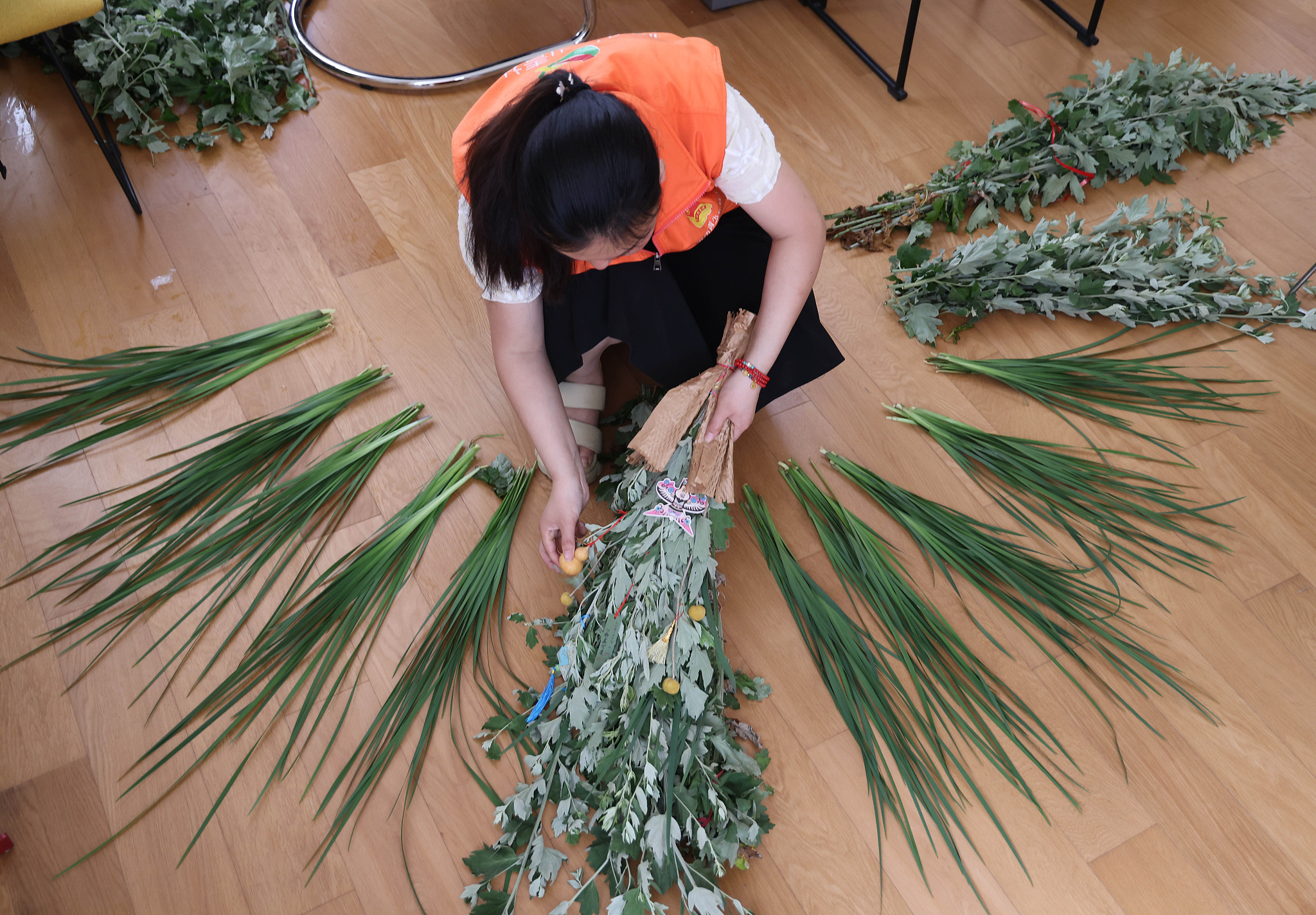A woman arranges mugwort for bouquets, east China's Shandong Province, June 8, 2024. /CFP