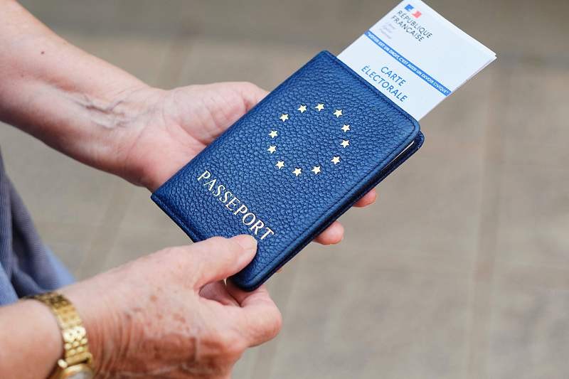A voter holds an identification document and electoral card before voting in the European Parliament election at a polling station in France's Pacific territory of New Caledonia, June 9, 2024. /CFP