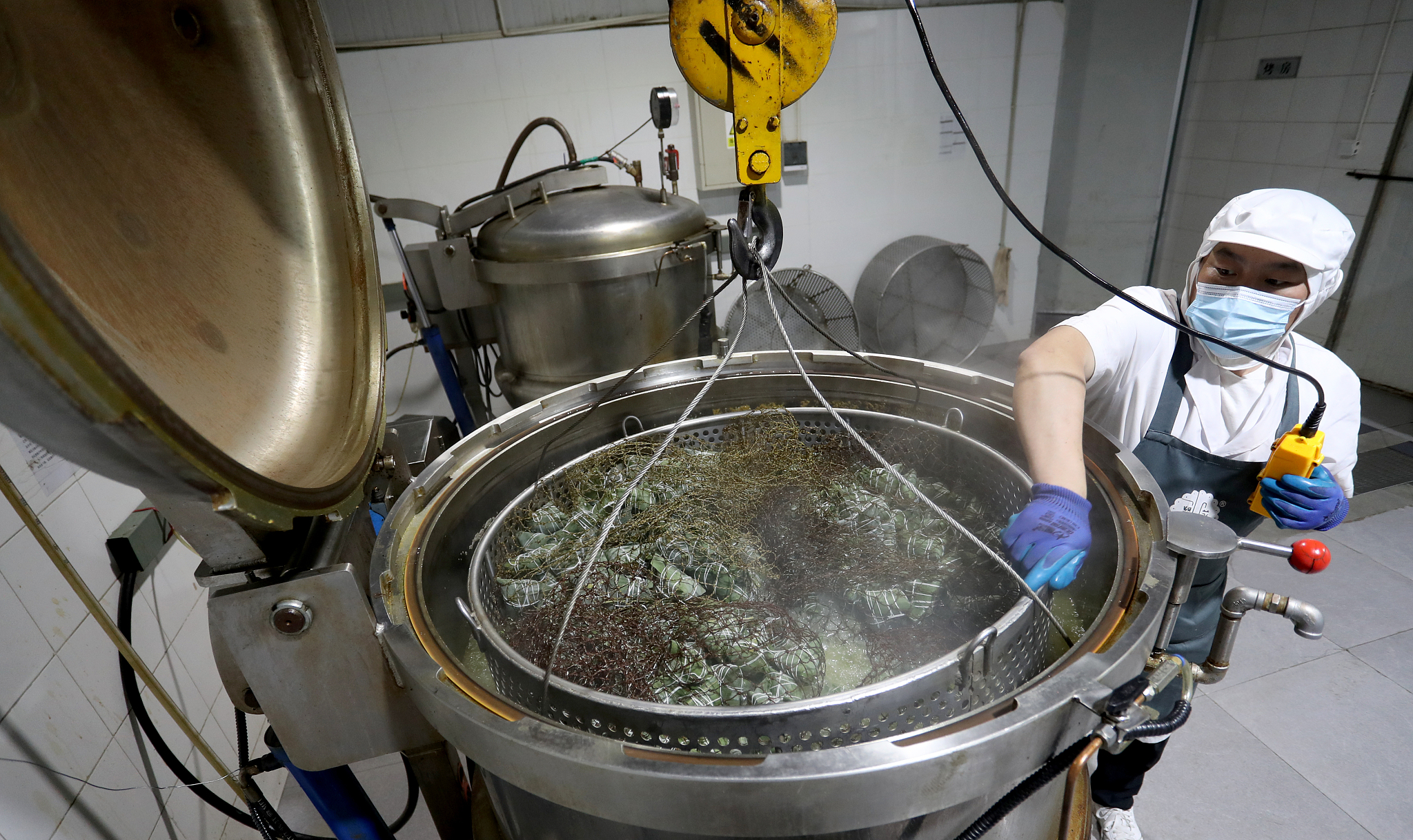 Baskets of rice dumplings are hoisted into a pressure cooker in a food factory in Chengdu, Sichuan Province, southwest China, June 9, 2023. /CFP